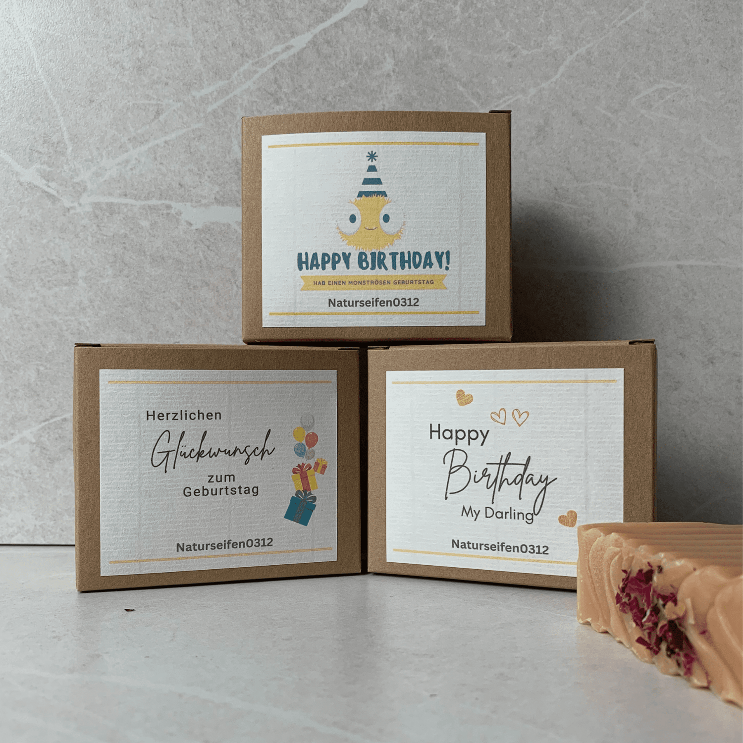 Drei Verpackungsschachteln mit verschiedenen Etiketten für Geburtstag