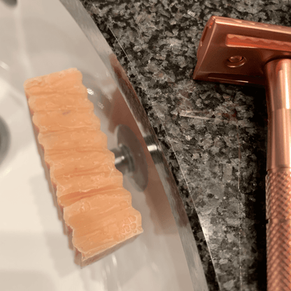 Seife am Magnethalter im Lavabo daneben ein Rasierhobel