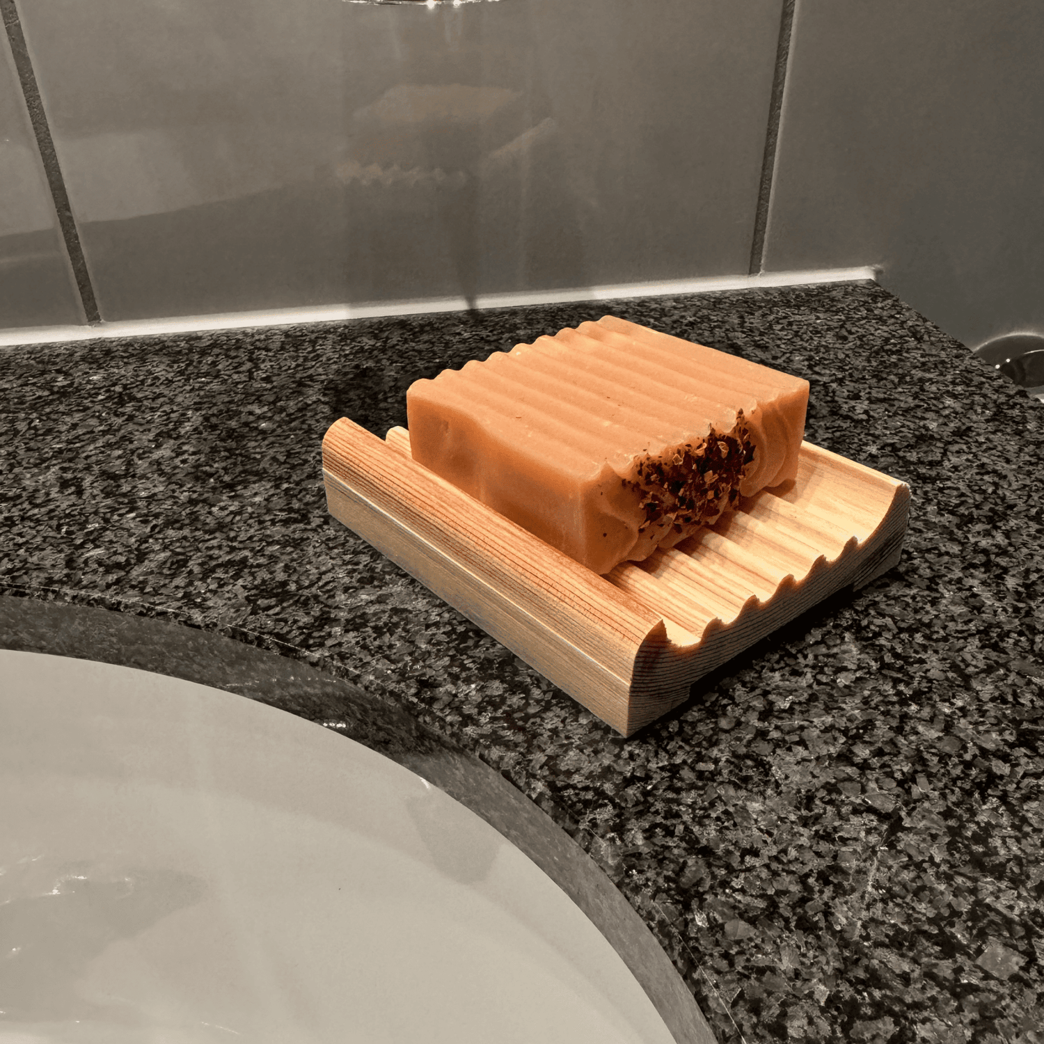 Seifenschale aus Holz mit einer Naturseife im Badezimmer
